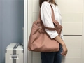 Detailopname van oudroze canvas shopper met brede schouderband gedragen door een model - Oudroze