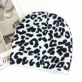 Close-up of fluffy black and white leopard print knitted beanie on white background - M (56-58cm) / Leopard Print