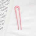 Pink U-shaped minimalist hair pin for buns shown on a white textured fabric background - Pink