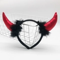 Detail of a red devil horn headband with black feather trim in a white metal basket - Red Shiny Horn with Black Feather and Black Headband