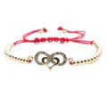 Dettaglio di bracciale in corda rossa intrecciata con ciondolo a cuore e infinito in zirconi - Cuore / Rosso