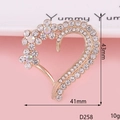 Macro shot of 43mm x 41mm golden heart brooch with rhinestones and flower details - D258 Flower Heart Gold White