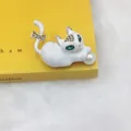 Dettaglio di una spilla a gatto bianco con occhi di strass verdi e perla centrale - Gatto con Perla Bianca