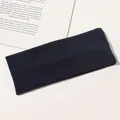 Detailed view of dark blue ribbed knitted headband on a minimalist background - Navy Blue