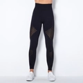 Detail of high-waisted black yoga pants with laser-cut hollow-out geometric patterns - Black