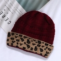 Close-up of wine red knitted beanie featuring a stylish leopard print folded cuff detail - One Size / Burgundy