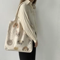 Minimalist beige canvas tote bag with various cartoon dog prints on casual shoulder model - Dog Illustration / Beige