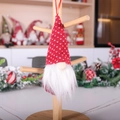Red knit gnome Christmas ornament with white dots and plush beard on wooden stand - Red Polka Dot Style