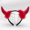 Close-up of red devil horn headband with shiny fabric and red feathers in a white basket - Red Shiny Horn with Red Feather and Black Headband