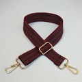 Close-up of red and green woven adjustable strap with gold metal buckles and chevron pattern - Wine Red Green Stripe / Gold Buckle