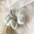 Close-up of soft fluffy faux fur scrunchie in light grey blue for autumn winter - Green