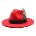 Detail of red wool fedora hat featuring black ribbon band and natural feather accent - M (56-58cm) / Red