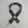 Detail of adjustable black bag strap with ethnic floral embroidery and gold metal hardware - No.3 Black and White Floral / Silver Clasp