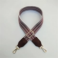 Detail of adjustable wine red and white geometric embroidered strap with gold buckles - Brown