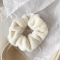 Close-up of a soft white plush scrunchie with fluffy texture on a minimalist tray - White