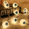 Catena luminosa bulbo oculare Halloween con iride blu su tappeto di pelliccia bianca - Malocchio / 3m 20-LED Alimentato a Batteria