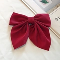 Detailed view of a large red satin bow hair clip on a minimalist magazine background - Satin Solid / Burgundy