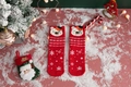 Detail view of festive red Christmas socks with cartoon bear and snowflake patterns - One Size / Red Bear Snowflake