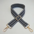 Detail of adjustable embroidered bag strap with black white chevron pattern and gold clips - Black