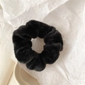 Close-up of soft black plush scrunchie with fluffy texture on white minimalist background - Black
