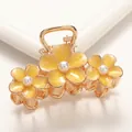 Detail view of yellow floral hair claw with central pearls and golden metal base - Large / Yellow