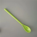 Close-up of lime green long handle melamine dessert spoon on gray background - Green