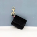 Detailed macro of black faux fur mini coin pouch with gold metal swivel hook and tassel - Black