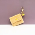 Dettaglio di mini portamonete in peluche con portachiavi dorato e nappa gialla decor - Beige