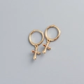 Dettaglio di orecchini a cerchio minimalisti in argento S925 con pendente a croce - Oro