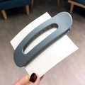 Minimalist matte grey hollow hair clip held by hand for daily hairstyling use - Light Blue