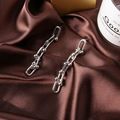 Polished silver U-shaped chain drop earrings displayed on elegant brown silk fabric - Long Style / Silver