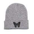 Close-up of a grey knitted beanie featuring a detailed black butterfly embroidery - M (56-58cm) / Gray