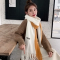 Écharpe tricotée en blanc et caramel avec franges, portée par un mannequin en café - Blanc avec bordure jaune