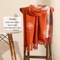 Écharpe pissenlit réversible orange et gris avec franges sur une chaise en bois - Orange