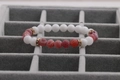 Macro detail of white stone and red agate beads with gold spacers on velvet - Red Weathering