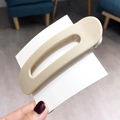Minimalist beige plastic hair clip for women shown held on a white card display - Beige