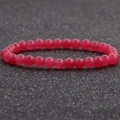 Vista detallada de una pulsera de cuentas de ágata roja de 6mm sobre un fondo negro texturizado - Rojo (10)