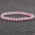 Detalle macro de la pulsera de cuentas de cuarzo rosa con textura rosa translúcida - Cuarzo rosa