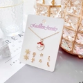 Gros plan du collier lune doré et boucles d'oreilles flocon sur carte blanche - Thème de Noël-Carte Blanche-Collier Lune Bonnet de Noël Doré et 3 Paires de Boucles d'Oreilles (Flocon/Étoile)