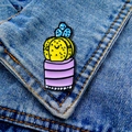 Detail van een creatieve cartoon cactus emaille speld op een blauwe denim jas stof - Gele Cactus-Paars gestreepte pot