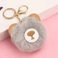 Close-up of a grey plush bear keychain with faux rabbit fur and gold metal clasp - Gray