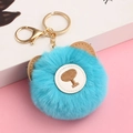 Close-up of blue plush ball teddy bear keychain with gold metal ring on pink surface - Bright Blue