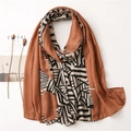 Detailed flat lay of caramel linen scarf with geometric stripes and soft pleats - Caramel color
