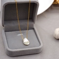 Goldkette mit natürlichem Barockperlenanhänger auf grauem Samt präsentiert - Gold