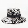 Detail of leopard print PVC bucket hat showing glossy texture and black ribbon trim - Transparent Leopard Print