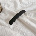 Dettaglio della texture opaca nera e della clip a molla in metallo sulla molletta capelli - Nero