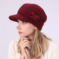 Detail view of burgundy knitted peak hat featuring a decorative side pompom and bow - One Size / Dark Red