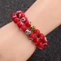 Red Evil Eye beaded bracelets with gold and silver Buddha head charms on display - Red Zirconia Set