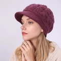 Detailansicht der lila Zopfstrick-Visier-Beanie mit dickem Ripprand an einem Model - Einheitsgröße / Fuchsia