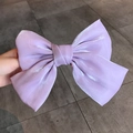 Große lila Satin-Schleifen-Haarklammer mit elegantem Glanz-Finish in der Hand - Hellviolett (Perlmutt)